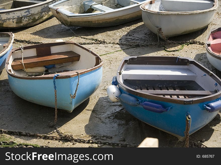A group of small rowing boats at low tide. A group of small rowing boats at low tide.