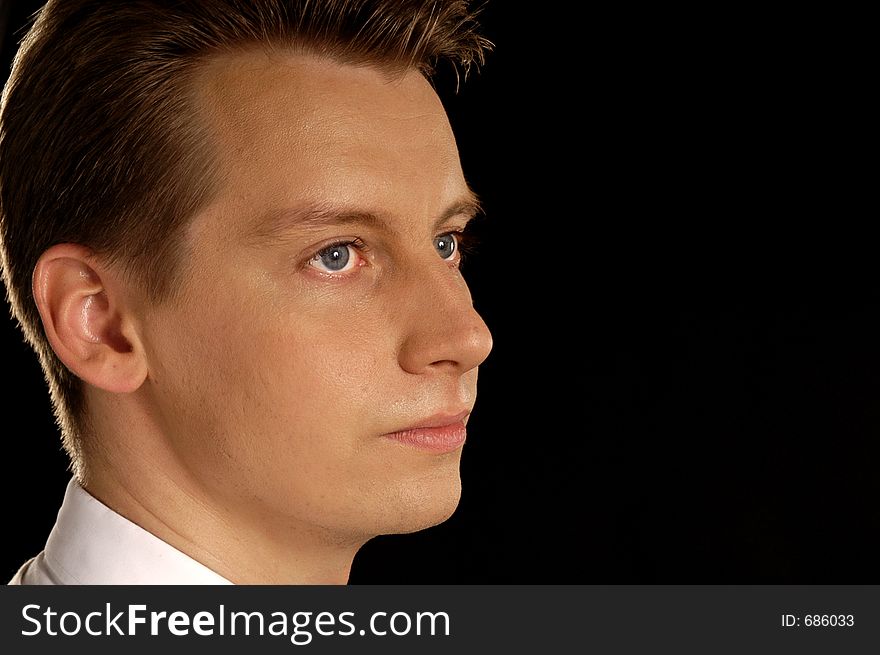 Portrait of attractive young man on isolated black background with copyspace. Portrait of attractive young man on isolated black background with copyspace