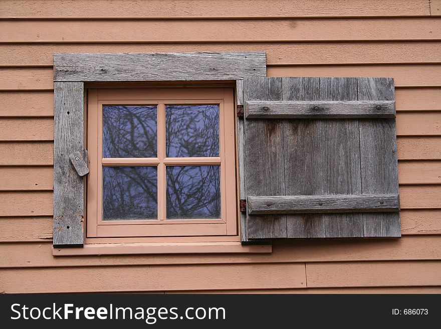 A small,shuttered window on an historic New England building