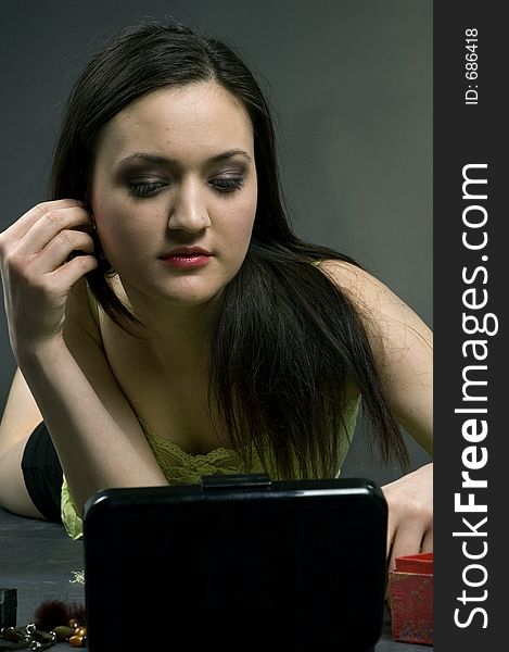 Young pretty girl arranging her hair, preparing to go out. Young pretty girl arranging her hair, preparing to go out.