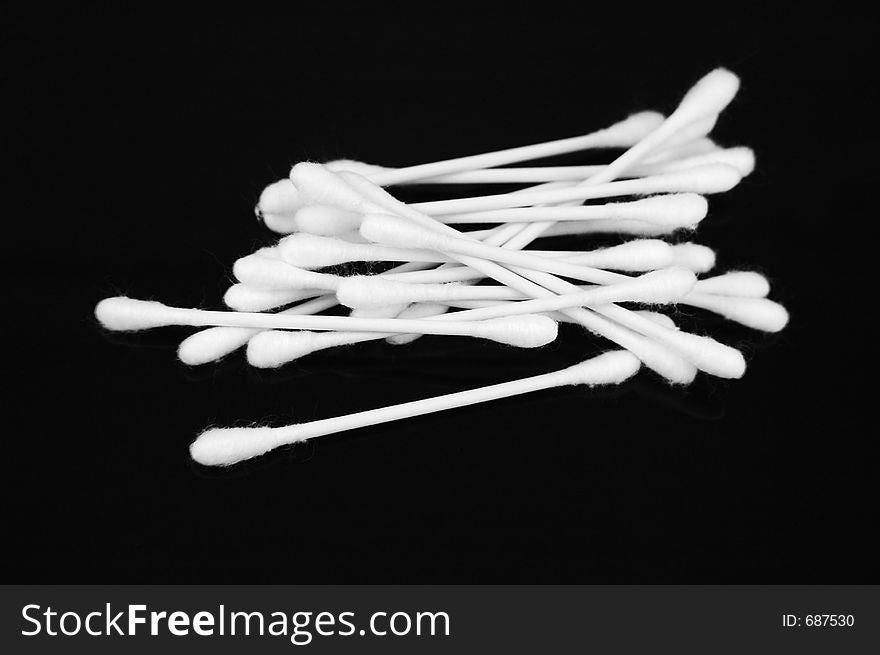 White cotton swabs on black background