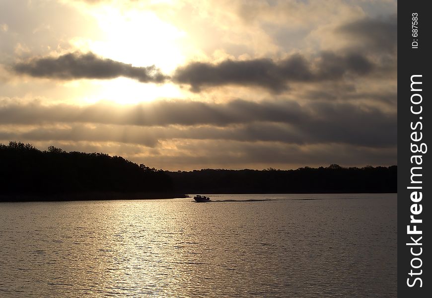 Lake sunset with fishing boat