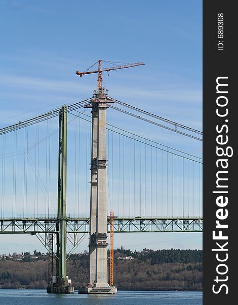 A bridge being built by a crane. A bridge being built by a crane