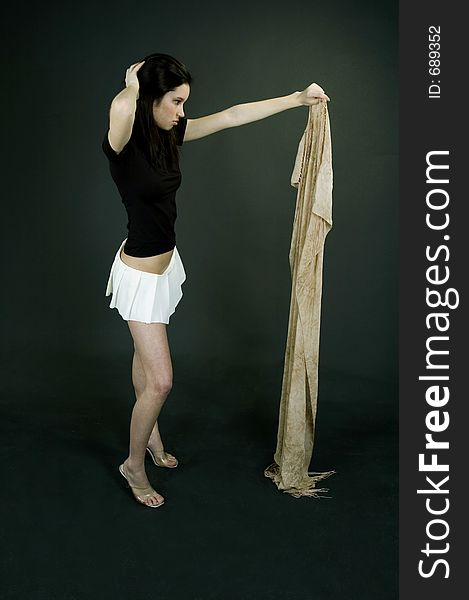 Young beautiful woman throwing away a beige scarf. Young beautiful woman throwing away a beige scarf