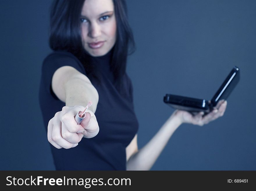 Attractive young woman holding some make-up and smiling with confidence. Attractive young woman holding some make-up and smiling with confidence