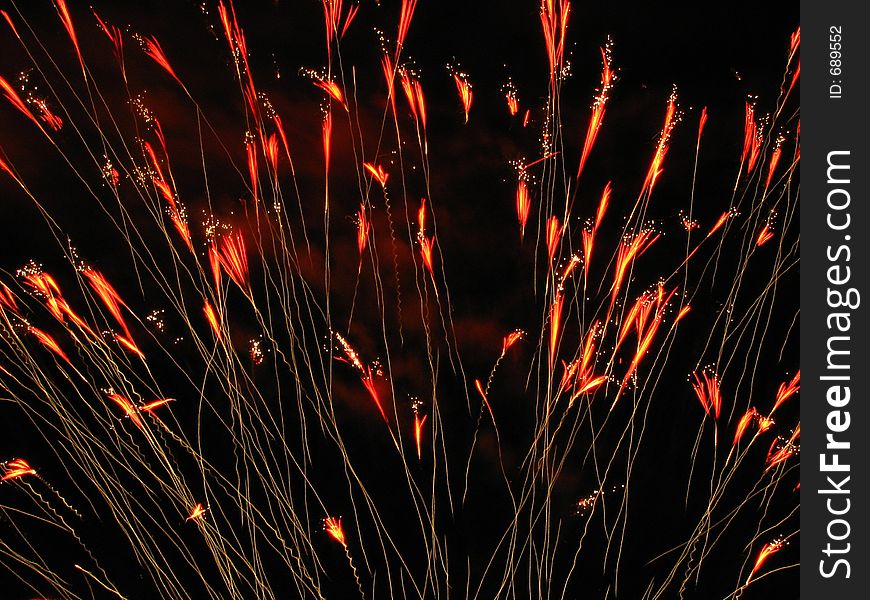 Fireworks blossoming upwards in shades of orange and red bursts. Fireworks blossoming upwards in shades of orange and red bursts