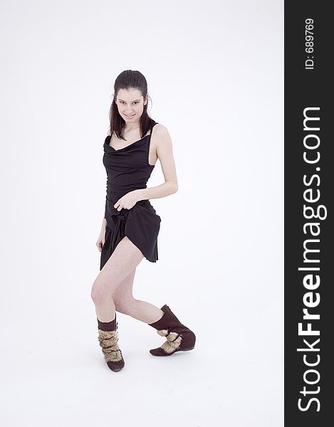 young dancer, in black short skirt and trendy fur boots, making a sensual move on a white studio background. young dancer, in black short skirt and trendy fur boots, making a sensual move on a white studio background