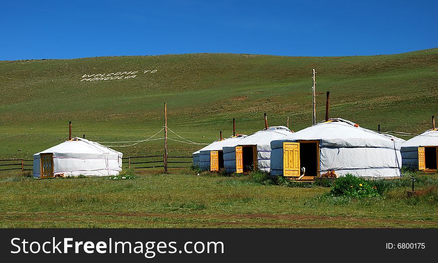 Some several white mongolian yurts in steppe of Mongolia. The doors are opened