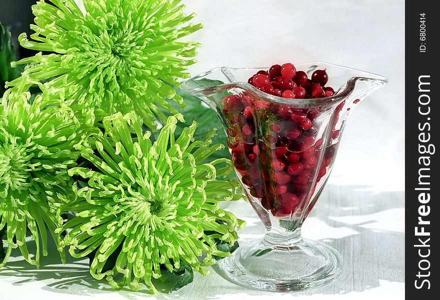 Red berry in glass and flowers