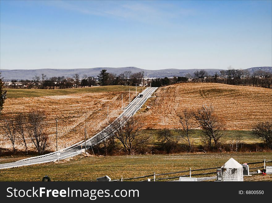 A beautiful landscape of autumn with a country road winding through it. A beautiful landscape of autumn with a country road winding through it.