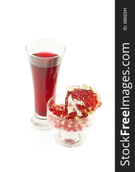 Glass of pomegranate juice and  grains and a pomegranate piece. Over white. Glass of pomegranate juice and  grains and a pomegranate piece. Over white.