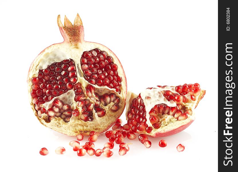 Pieces of a pomegranate and pomegranate grains. Over white. Pieces of a pomegranate and pomegranate grains. Over white.