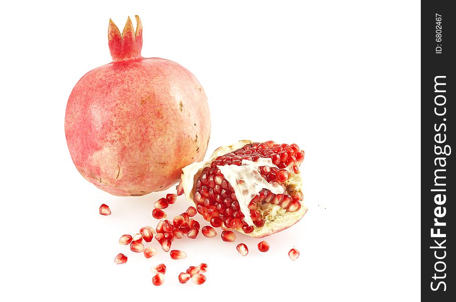 Pomegranate, a piece of pomegranate and scattered pomegranate grains. Over white. Pomegranate, a piece of pomegranate and scattered pomegranate grains. Over white.