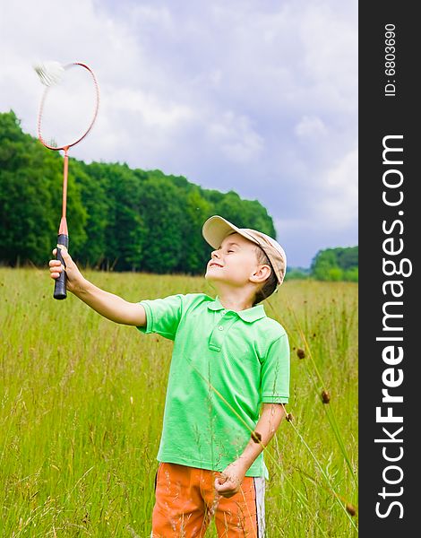 Cute kid playing badminton outdoors