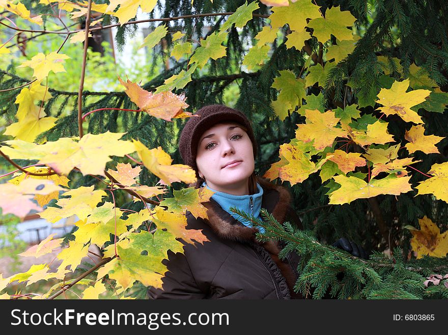 Autumnal portrait of a girl among leaves
