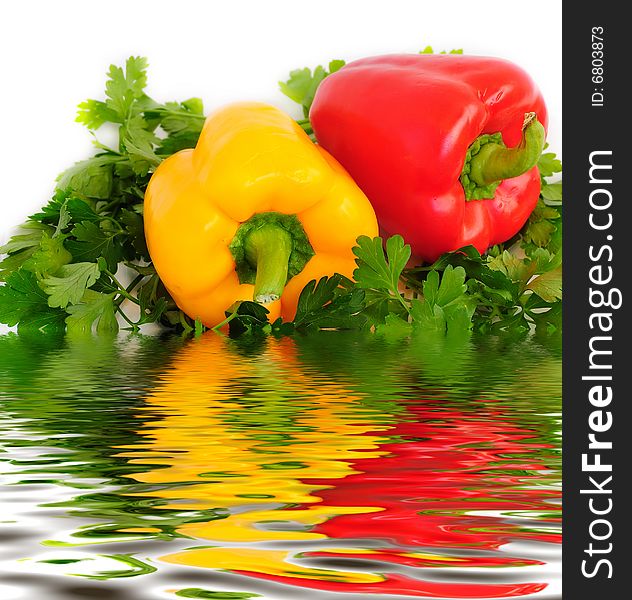 Two sweet peppers (paprika), parsley and reflection in water