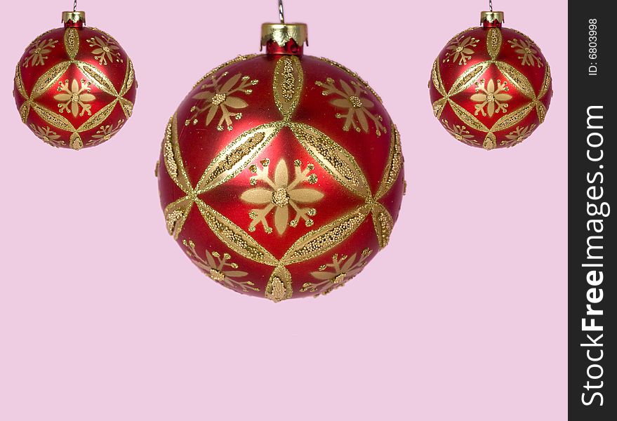 Red and gold Christmas ornaments against pink background. Red and gold Christmas ornaments against pink background