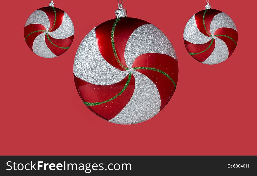 Glittery circle shapes Christmas ornaments against red background. Glittery circle shapes Christmas ornaments against red background