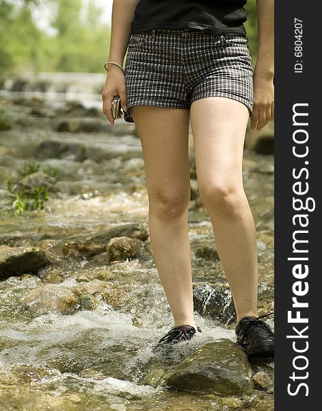 Young woman walks in a stream showing legs only. Young woman walks in a stream showing legs only