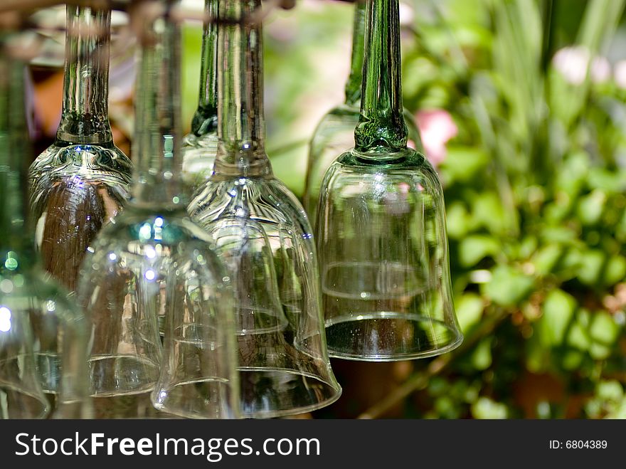 Green glass goblets hanging upside down