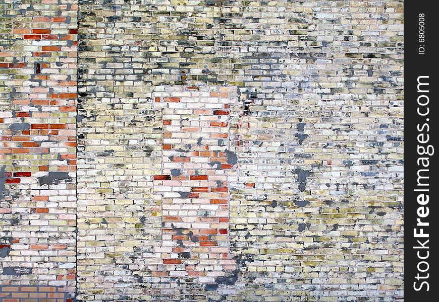 Weathered brick wall with multi-colored painted bricks