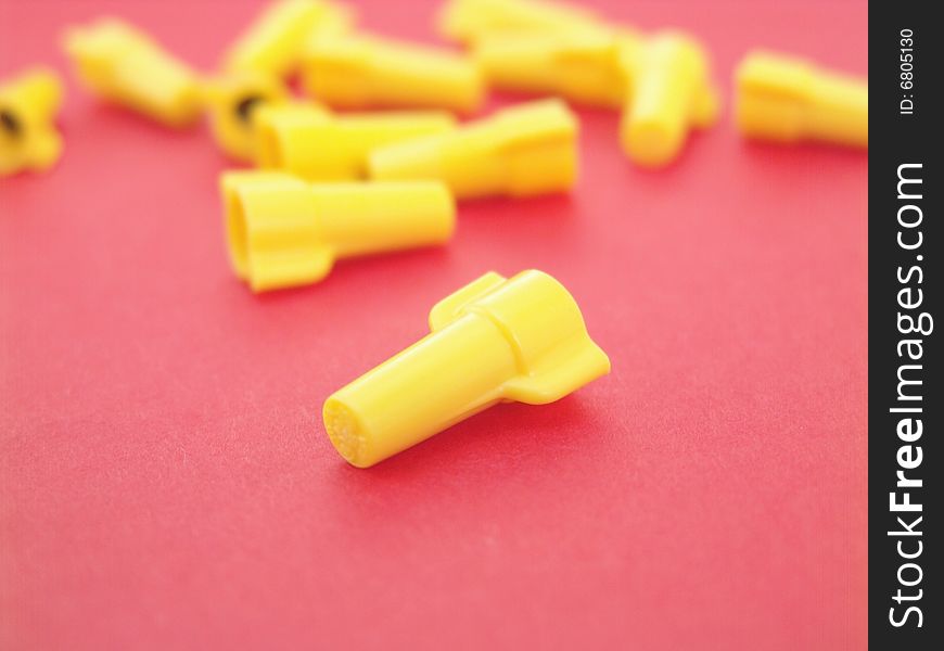 Yellow wire nuts isolated on red background