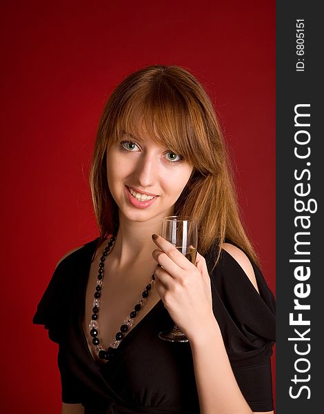 Sensual girl with champagne glass on dark red background