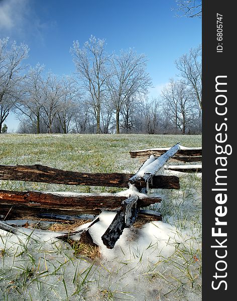 An old fashioned wood link fence covered in snow and ice on an otherwise clear and nice day. An old fashioned wood link fence covered in snow and ice on an otherwise clear and nice day.