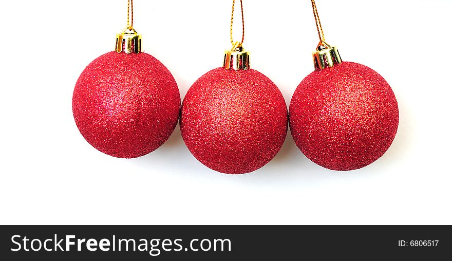 Three shiny red christmas baubles on white