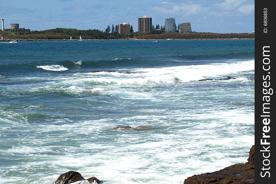 Rocks, surf and city skyline on the Sunshine Coast. Rocks, surf and city skyline on the Sunshine Coast.