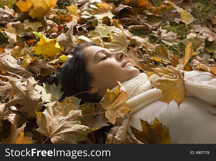 Sleeping autumn day woman lying in leafes. Sleeping autumn day woman lying in leafes