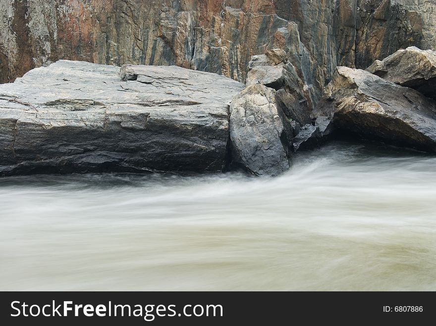 Long exposure motion blurred river and granite stone. Long exposure motion blurred river and granite stone