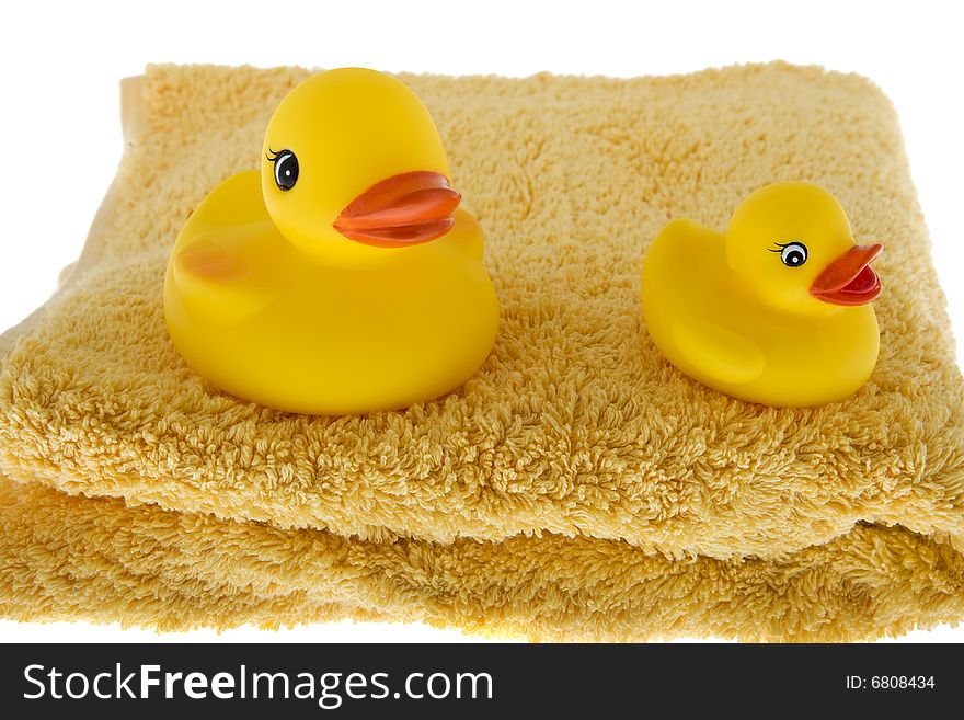 Rubber duck sits on towel, toys made of plastic for taking a bath