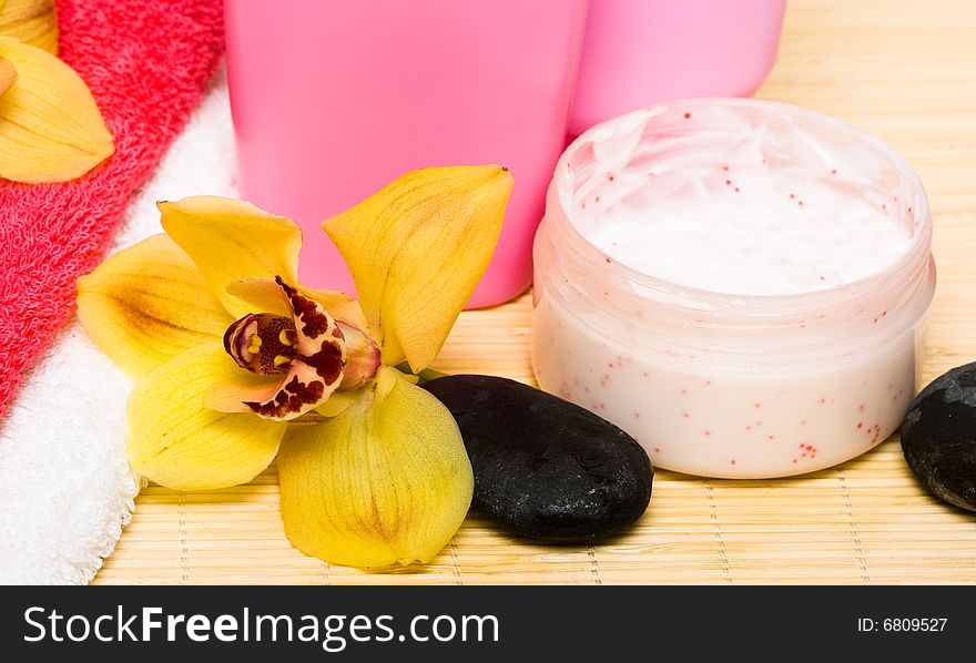 Cream, bottle of shampoo with stone and orchid