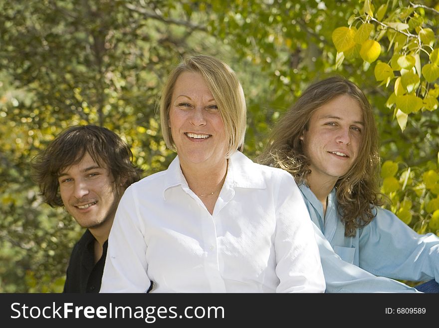 Photo of single mom with her two teenage boys. Warm tones with fall background. Relatively shallow DOF with focus on the mother. Photo of single mom with her two teenage boys. Warm tones with fall background. Relatively shallow DOF with focus on the mother.