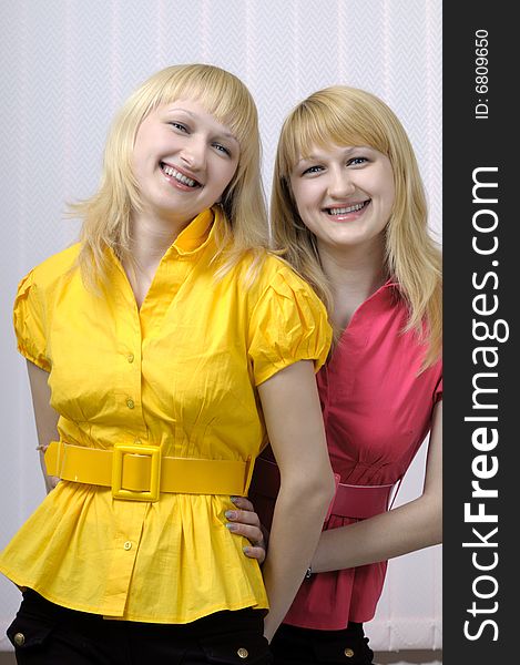 Two smiling blond sisters together