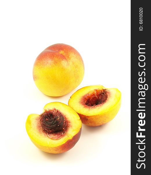 Two nectarines on white isolated background, one is cut to show the stone inside.