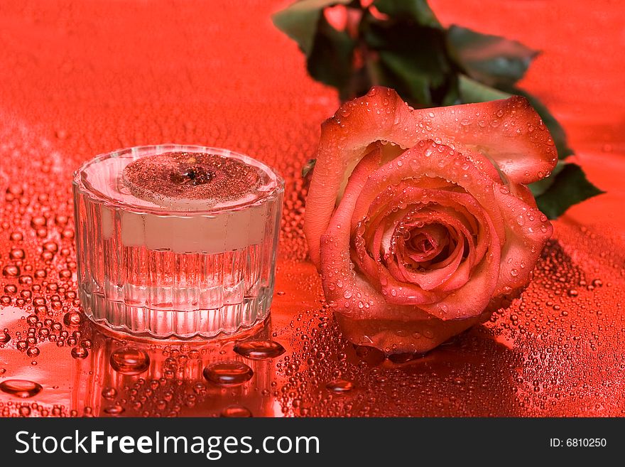 Candle with rose on red background