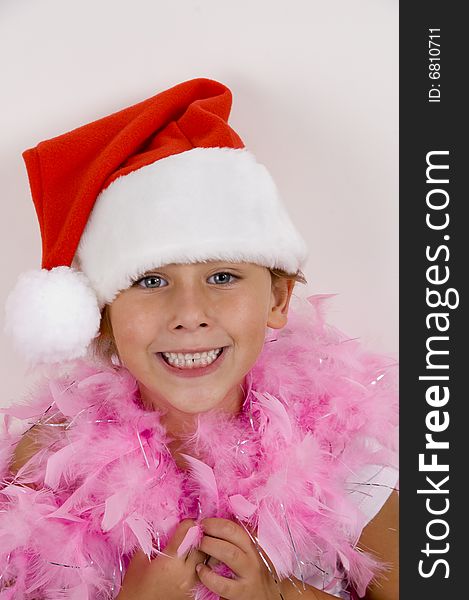 Portrait of smiling cute girl with christmas hat and pink feather scarf