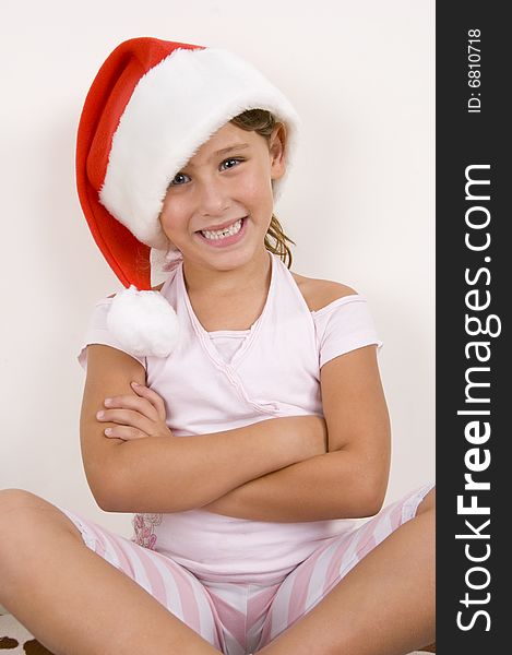 Smiling girl with her arms crossed wearing christmas hat