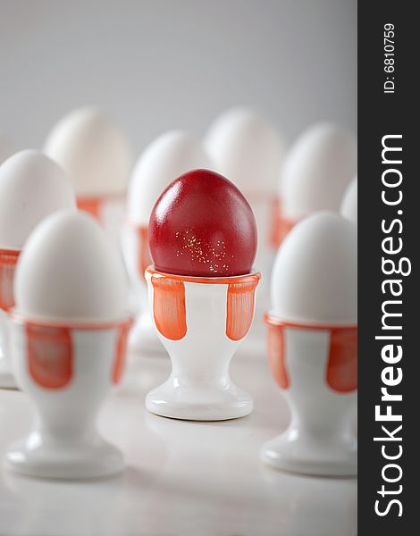 Red egg with dozen white eggs, easter and concept