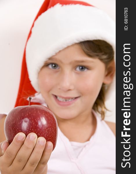 Girl wearing christmas hat and holding an apple