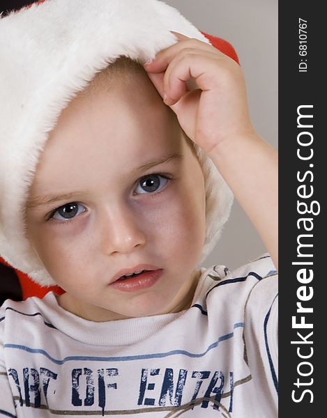 Little boy wearing christmas hat and looking at camera