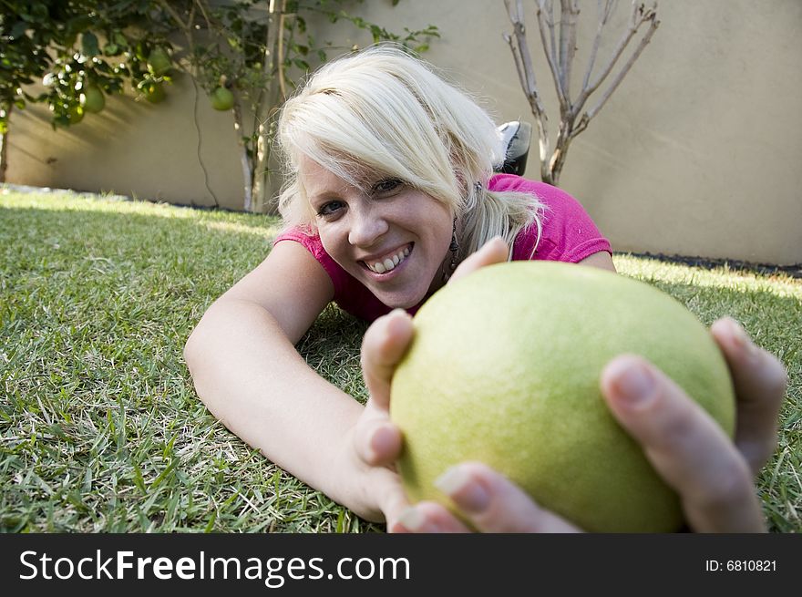 Caucasian woman posing with sweet lime on the grass