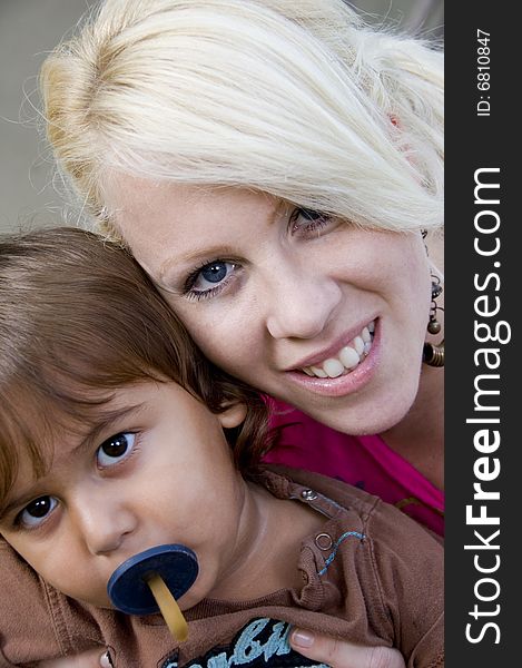 Boy with pacifier posing with his mother. Boy with pacifier posing with his mother