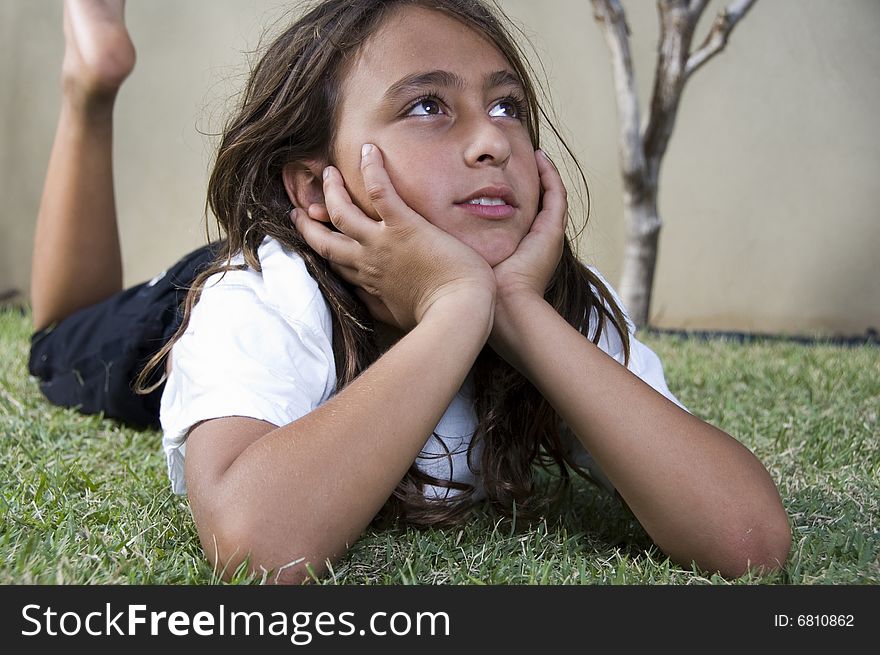 Little cute boy lying on grass and looking aside