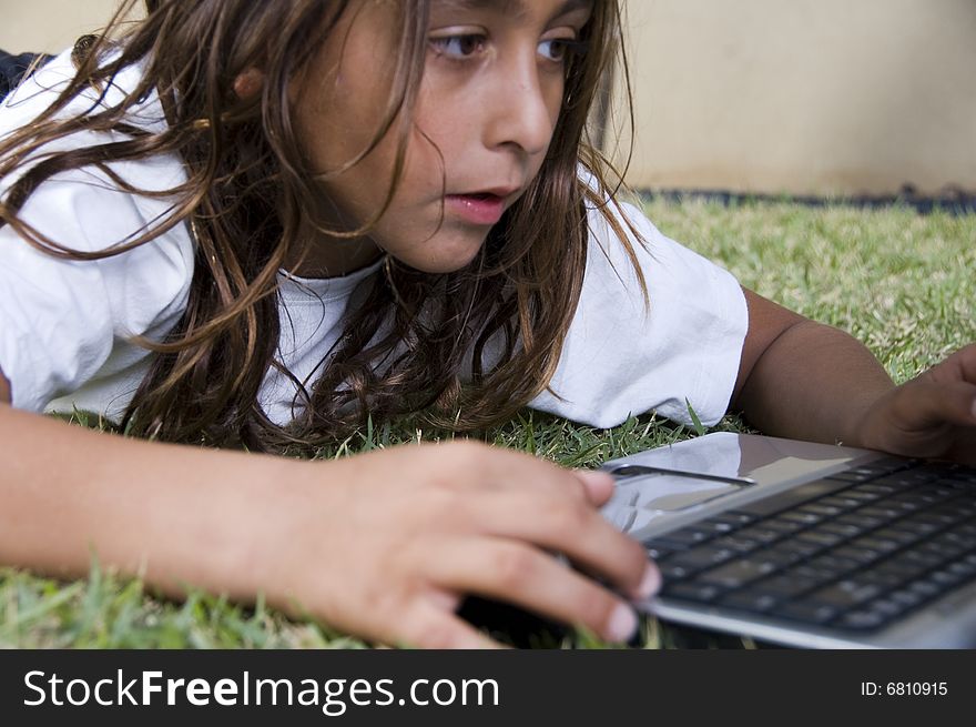 A lying little american boy playing with laptop