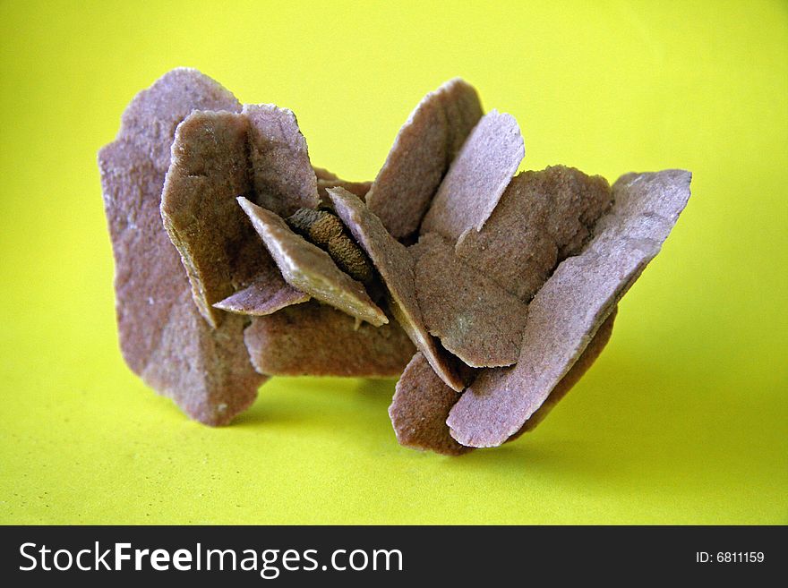 Mineral sample of gypsum, variety Desert Rose found in South Australia, with yellow background. Mineral sample of gypsum, variety Desert Rose found in South Australia, with yellow background.