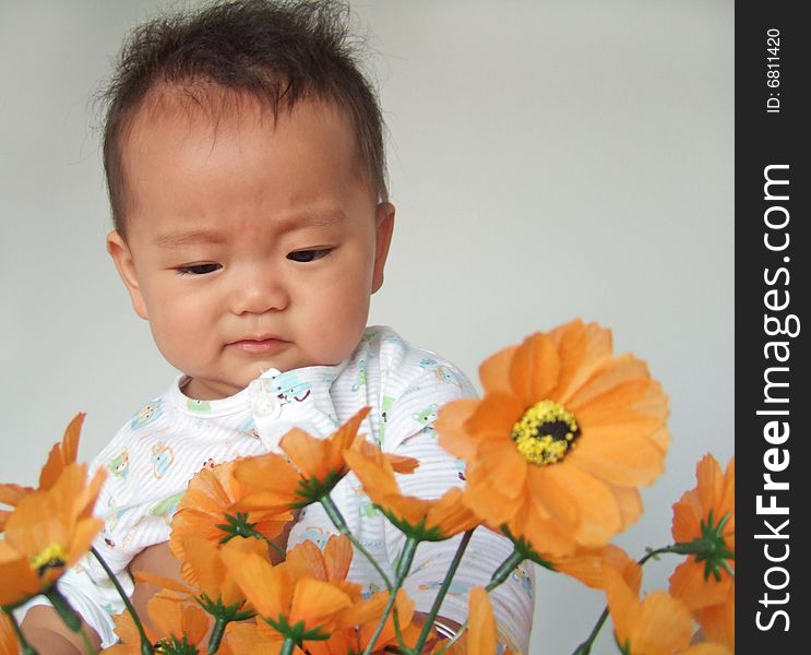 A cute baby and flowers. A cute baby and flowers