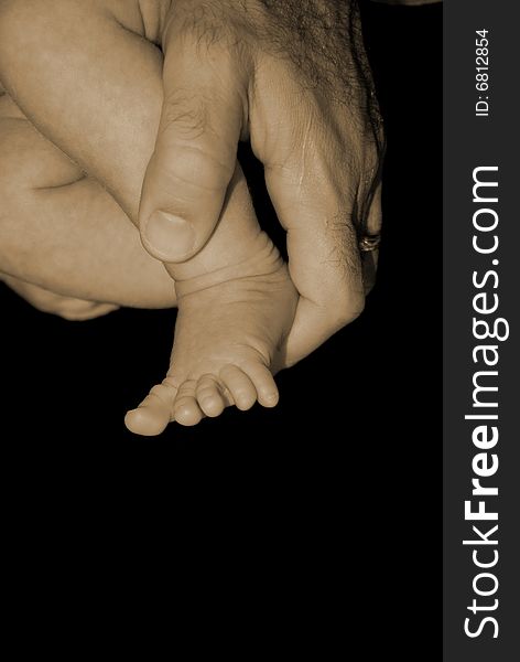 Father Holding Baby Foot Sepia